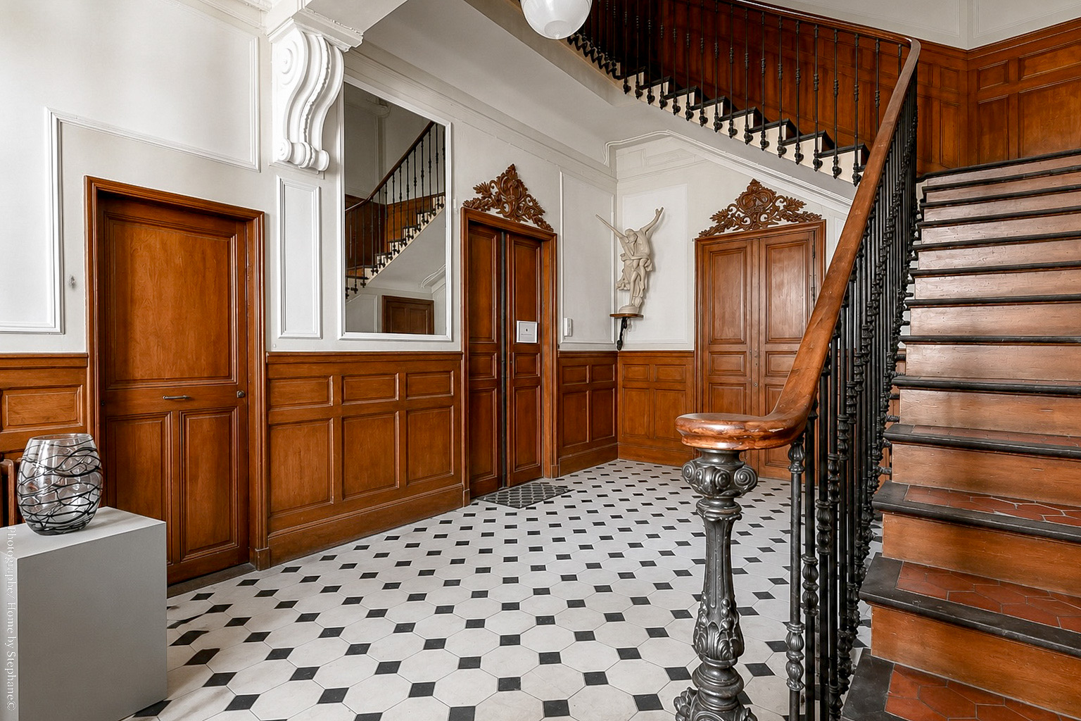 Hall de l'immeuble, sol en damier et escalier d'origine
